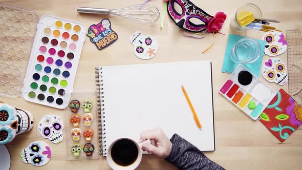 Step by step. Flat lay. Baker sketching a design of a cake for Dia de los Muertos holiday.