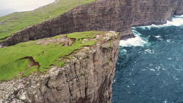 Aerial view of woman walking on the edge of tourists English Slave cliff.