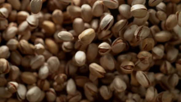 Super Slow Motion Shot of Pistachios Flies After Being Exploded Against Black Background, 1000Fps.