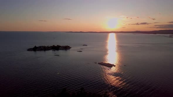 Small Rocky Islands in Big Blue Lake at Sunset, Drone Aerial Wide Dolly In. Flying over Wild Natural