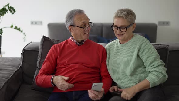 Happy Senior Couple with Smartphone at Home