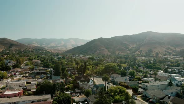 Aerial view of american suburb, San Luis Obispo. Drone flies forward over residential area, United S