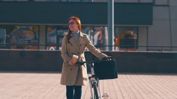 Smiling businesswoman going near bike