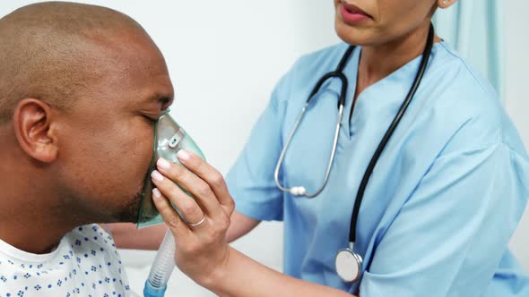 Doctor putting an oxygen mask on the patient