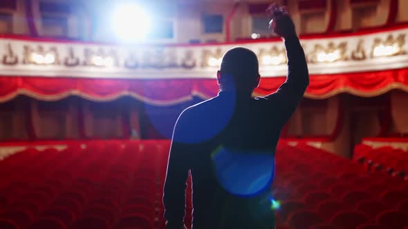 Theater auditorium with no people. Actor on a stage in front of empty hall.