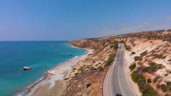 Aerial view flying over a road near the beach and coast of the Mediterranean Sea in Paphos Cyprus