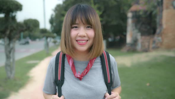 Asian woman feeling happy smiling to camera holiday trip at Ayutthaya, Thailand, backpacker enjoy.