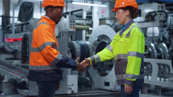 Businesspeople Shaking Hands at Machinery Plant