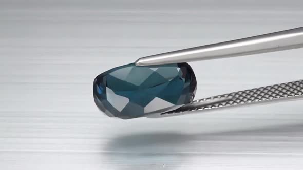 Natural London Blue Topaz Cushion Cut in the Turning Tweezers