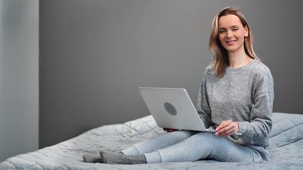 Casual Domestic Woman Smiling Sitting on Bed Posing with Laptop at Home