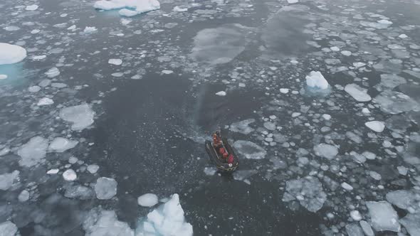 Zodiac Motor Boat in Icebergs Tracking Aerial Top Down View