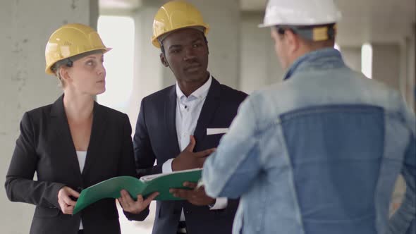 Businessman Working with Architect Engineer in Building Construction Site with Blueprint Checking