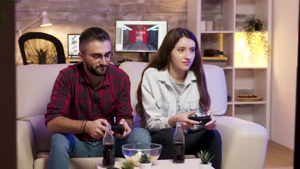 Joyful Young Couple Sitting on the Couple and Playing Video Games