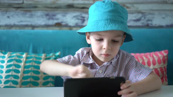 Cute Boy Using Smartphone Sitting in Cafe