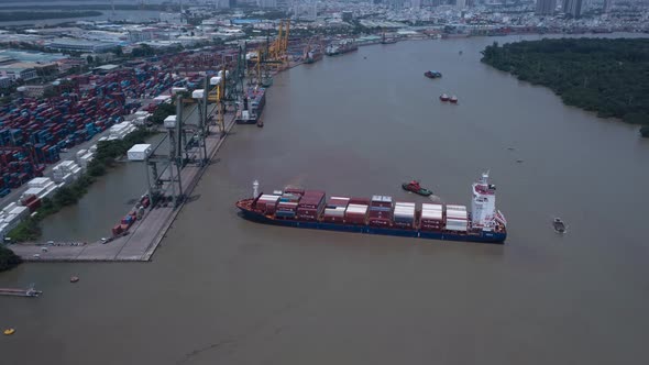 Hyperlapse of a large container ship being turned around by tug boats and leaving the port on a sunn