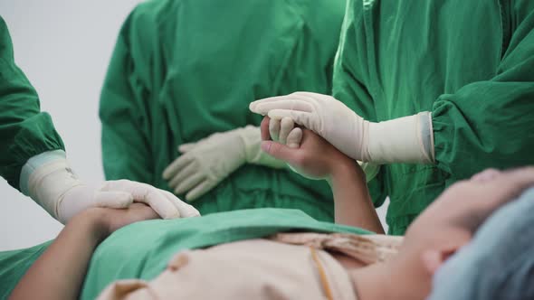 Asian group of doctor and nurse give courage to patient by hold hand and touch shoulder in hospital.