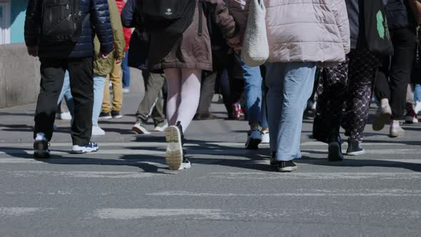 crowd of people walking along the city street, a view from below on the feet of passers-by, many p