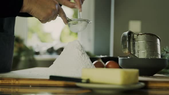 Woman sieving flour for cookie dough