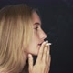Young woman smoking cigarette, turning and smiling over shoulder - VideoHive Item for Sale
