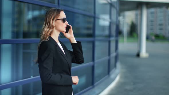 Focused Businesswoman Use Phone Discussing Work at Cityscape