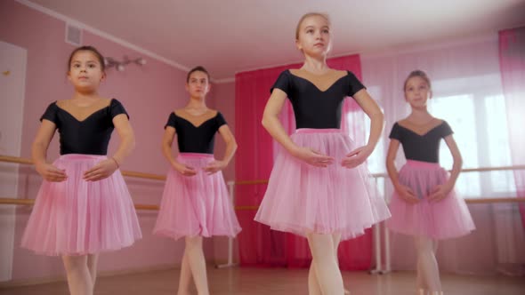 Four Ballerina Girls in Beautiful Dresses Practicing Ballet Dancing