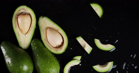 Falling Cut Fresh Avocados in the Water