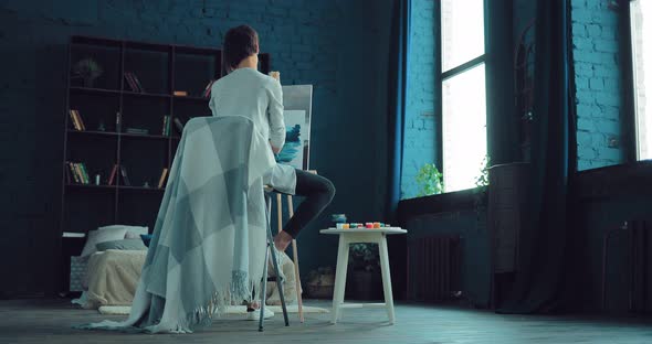 Beautiful and Young Girl Paints a Picture of Oil on Canvas in a Bright Room