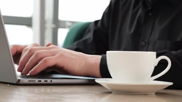 Working on a Laptop with a Cup of Coffee