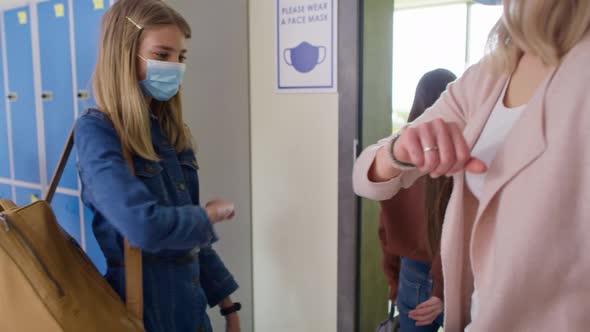 Video of female teacher greeting at school with their elbows. Shot with RED helium camera in 8K