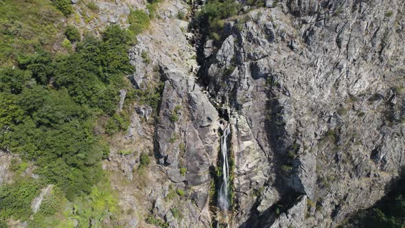 Aerial descending towards magnificent waterfall High stone Cliff - Mizarela