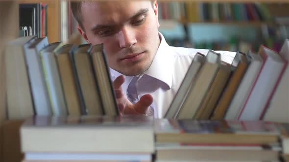 Boy Chooses a Book in the Library. Close Up. Slow Motion