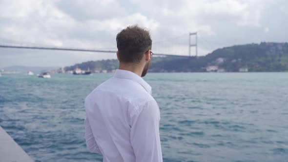 Thoughtful man in suit by the sea.