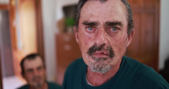 Close up of senior man looking serious in camera at home indoor