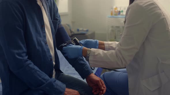 Physician Hands Putting Medical Cuff on Patient Arm Close Up