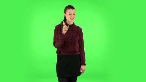 Girl Listens Carefully, Threatens with a Finger Seductively. Green Screen