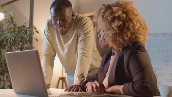 African American Colleagues Working Together in Office at Night