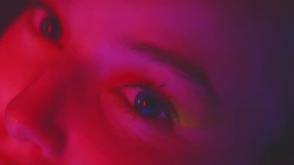 Close up of female eyes with red neon lights