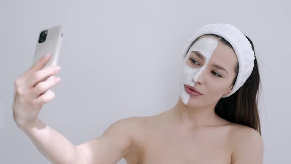 Portrait of Woman with Facial Mask Taking Selfie in Spa