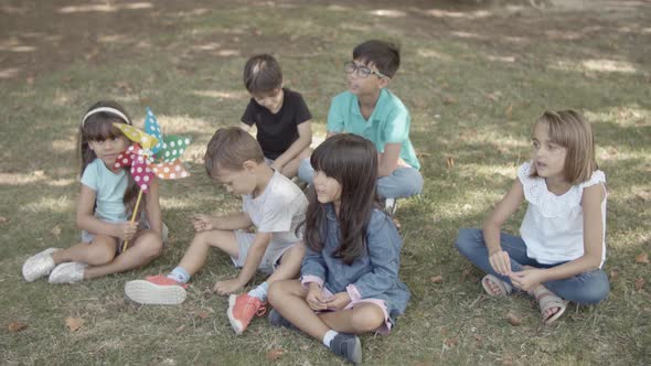 Multiethnic Children Sitting on Grass in Park Together