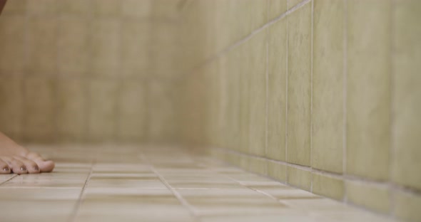 Woman Walking On Tiles Of Bathroom