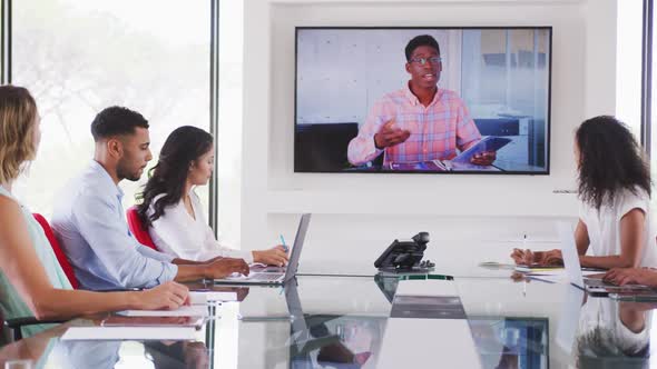 Professional businesspeople in video conference in meeting room in modern office in slow motion