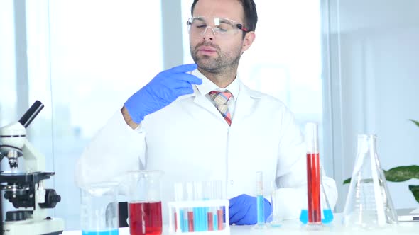 Scientist Examining Reaction in Watch Glass in Laboratory