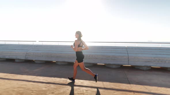 Sportswoman Jogging Near Port in Morning