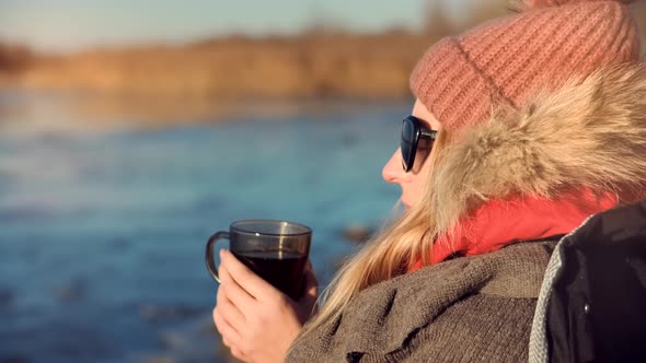 Female Drinking Hot Tea Or Coffee From Mug. Woman Warming Hands Steaming Cup Of Mate Tea.