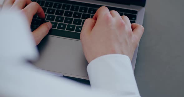 Man Typing on Keyboard Laptop Computer in Office