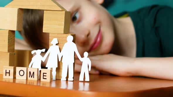 Caucasian boy preschooler plays, built a house from cubes, made the inscription home