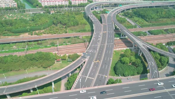 Aerial View of a Highway Overpass Multilevel Junction with Fast Moving Cars Surrounded By Green