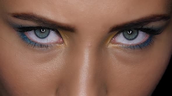 Girl Looks Fierce and Terrible Gaze Upwards. Close Up. Black Background. Slow Motion