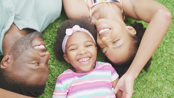 Portrait of happy african american couple with their daughter playing in garden