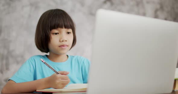 asian girl writing and look at laptop, Thai young kid learning online at home